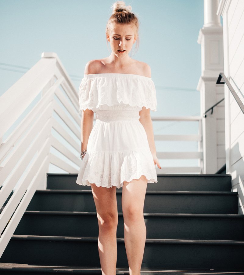 Woman in a white dress walking down white steps